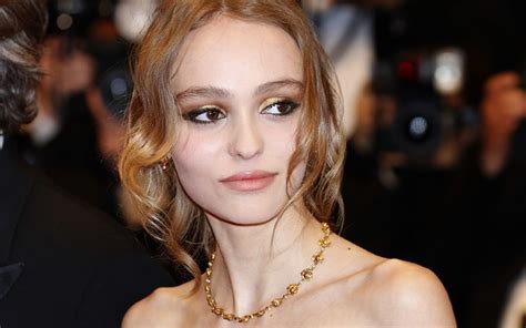 Lily Rose Depp poses topless and flashes her assets in a sheer top.